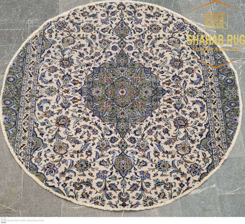 A detailed, elegant Kashan Persian rug with a central medallion on a crimson field